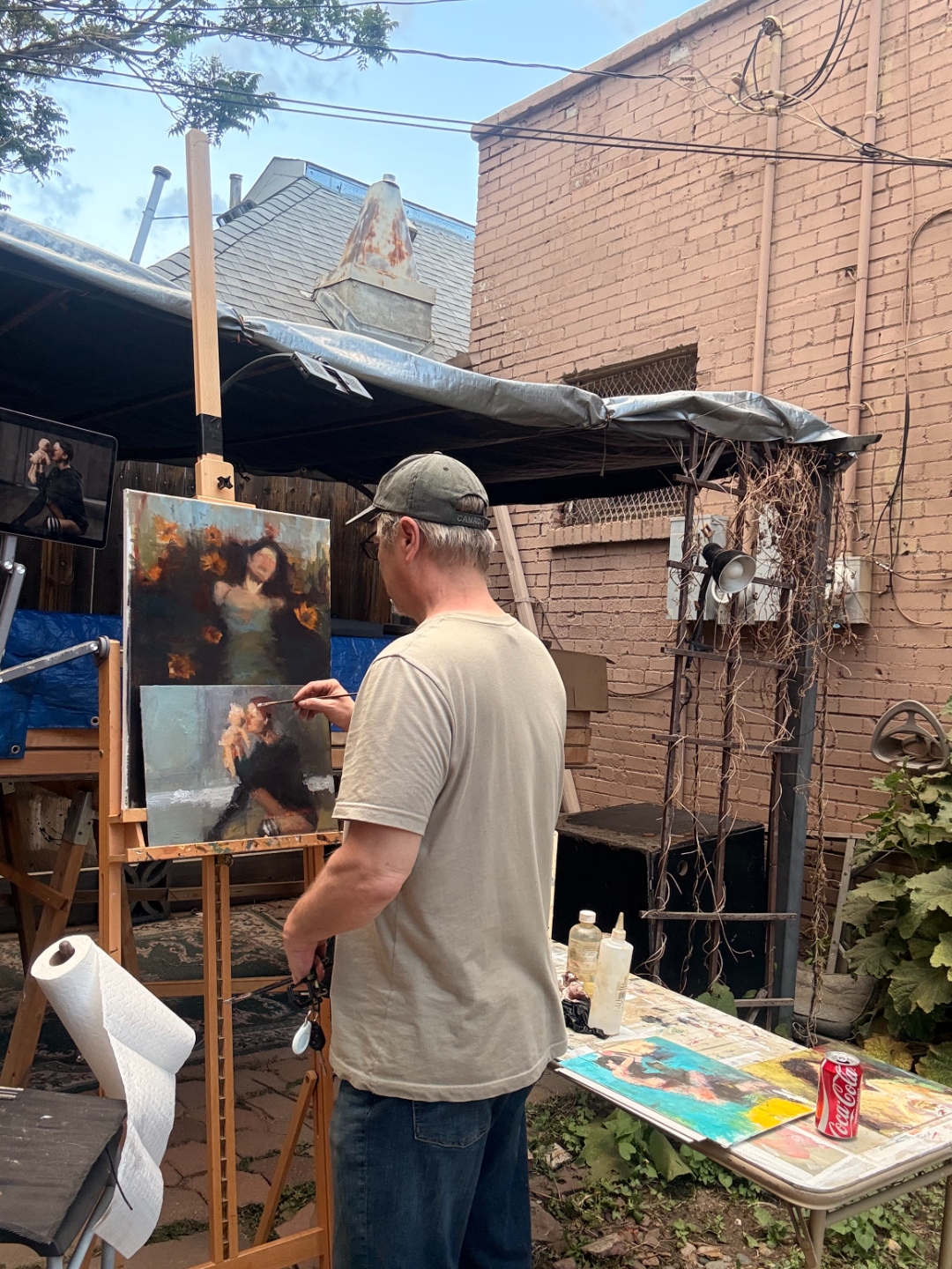 Long shot of Chad painting Ophelia outdoors with reference on an iPad